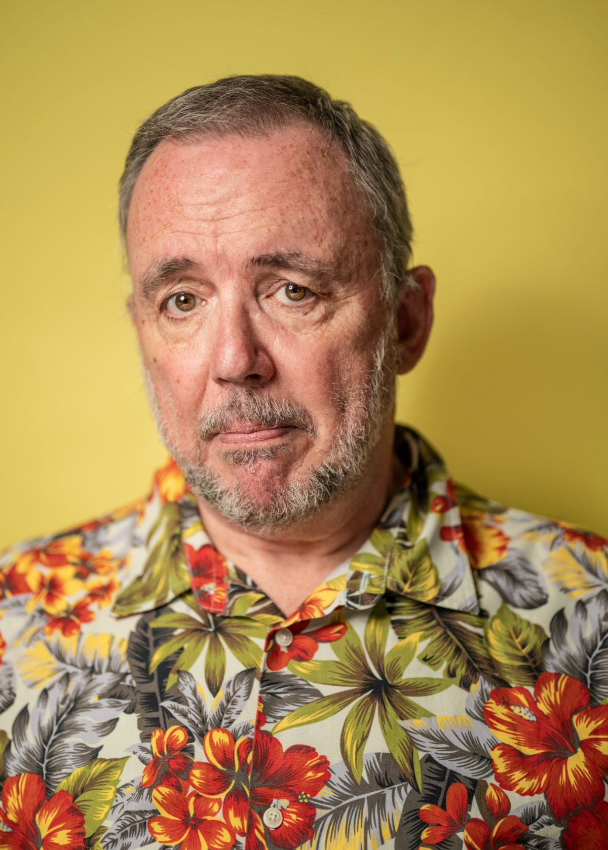 Charlie Lark in a floral shirt on a yellow background